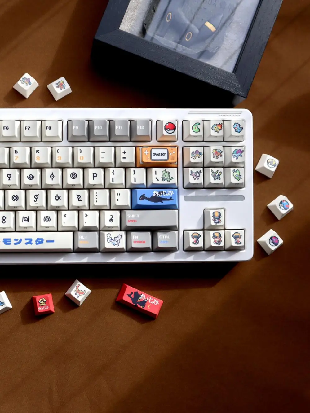 Mechanical keyboard featuring Pokemon Unown keycaps with pixel art novelties of Lugia, Ho-Oh, and Johto starters.