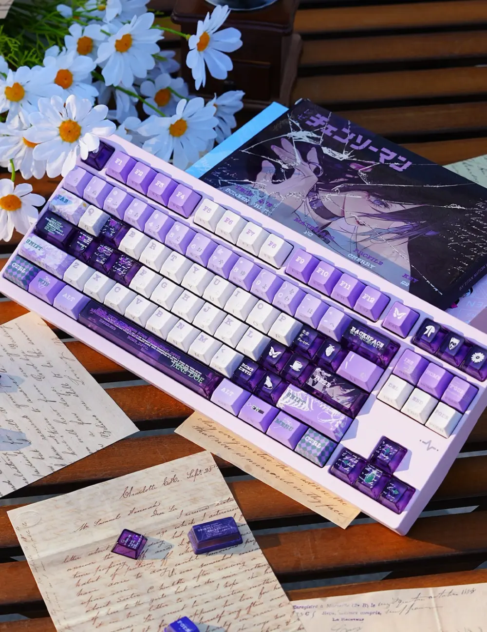 Chainsaw Man Reze Keycaps on Keyboard with Box Mechanical keyboard featuring Chainsaw Man Reze Keycaps in purple and white, alongside themed anime box and daisies.