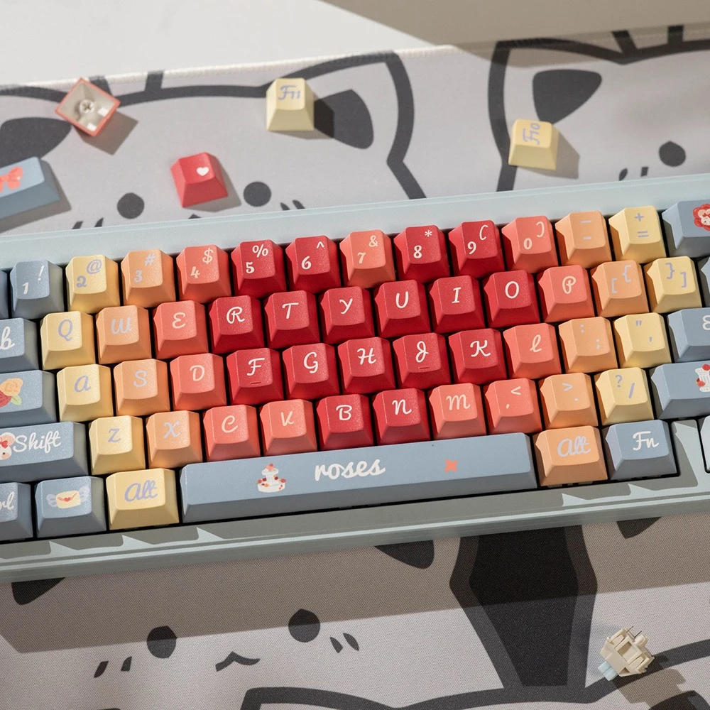 Roses Poem PBT keycaps on cat-themed desk mat with extra keycaps scattered around the keyboard