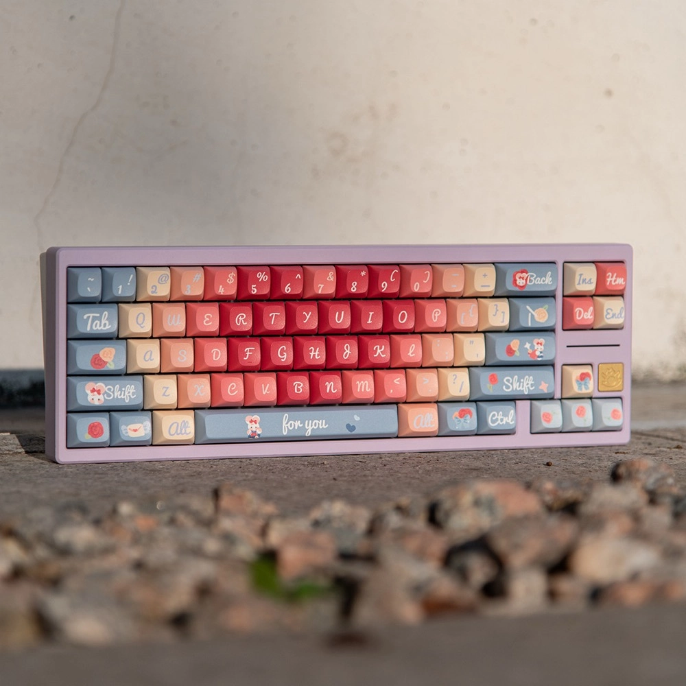 Roses Poem pastel PBT keycaps on keyboard angled front view on concrete desk surface with decorative novelty keys visible