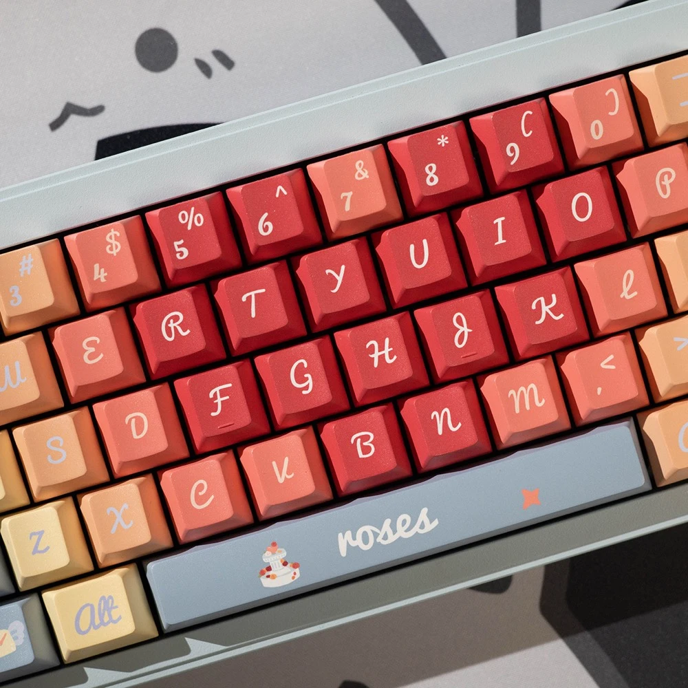 Close-up of Roses Poem keycap set in Cherry Profile showing taller sculpted keys, roses script on spacebar, gradient red-to-peach pastel tones, and cake novelty key