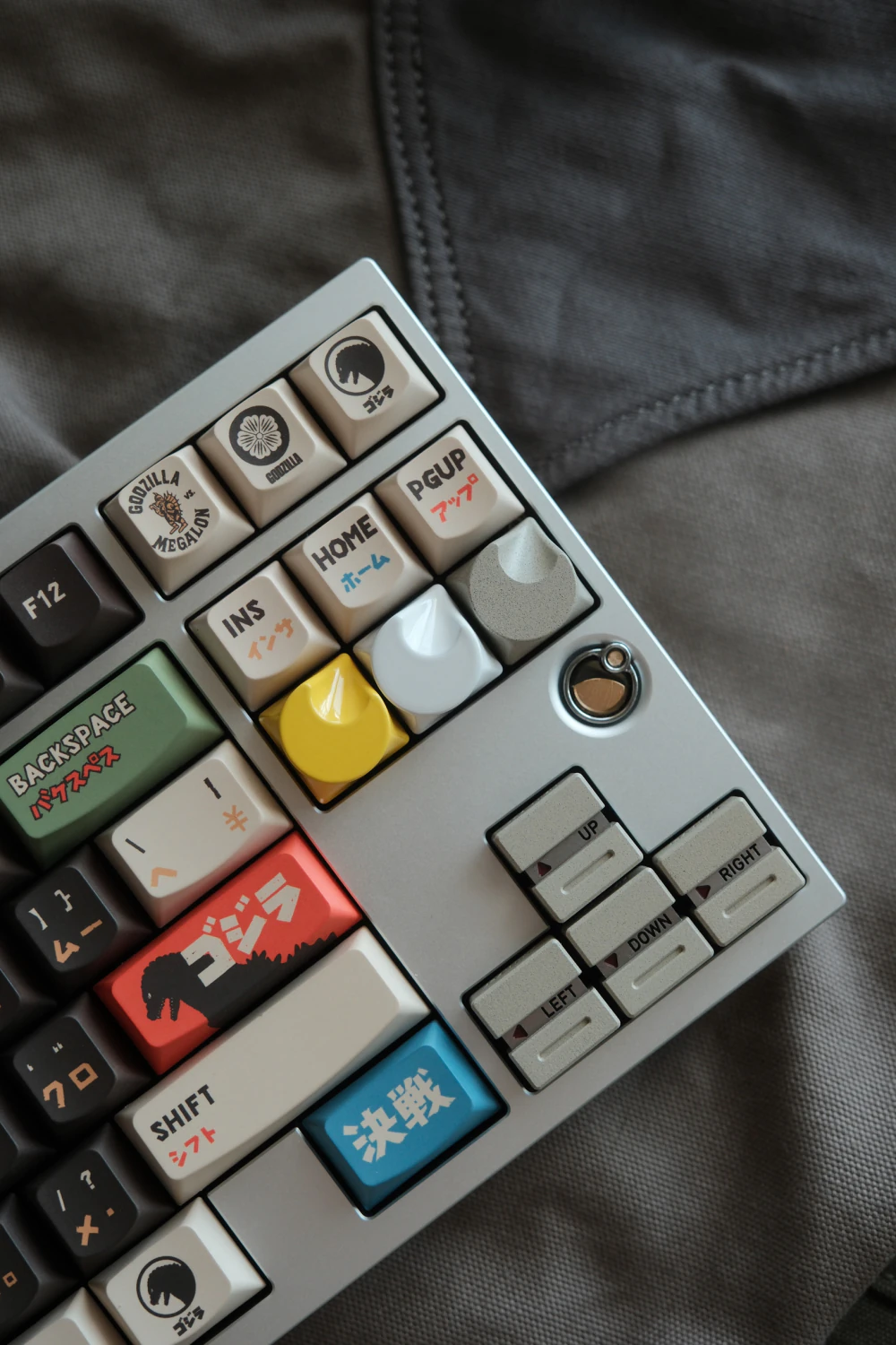 Artisan aluminum keycaps in three colors featuring a crescent moon dome shape mounted on a mechanical keyboard layout.