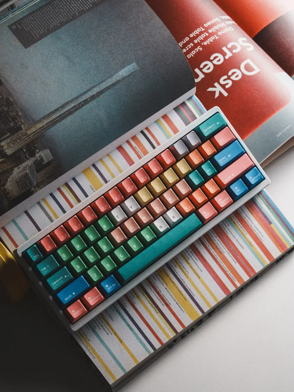 Fantasy Bean Y2K Cherry Profile Keycaps - Lifestyle Shot Fantasy Bean Y2K PBT Cherry profile keycaps in vibrant colors arranged on a keyboard over a magazine spread.