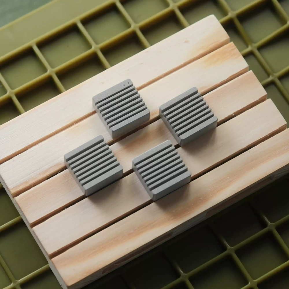 Heatsink Inspired Metal Artisan Keycaps on Wood Linen grey CNC machined aluminum arrow keycaps with ribbed heatsink design on a wooden surface.