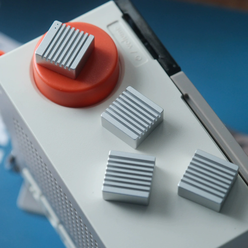 Silver Heatsink Metal Artisan Keycaps on Device Silver heatsink-inspired metal artisan keycaps for arrow keys placed on a white device.