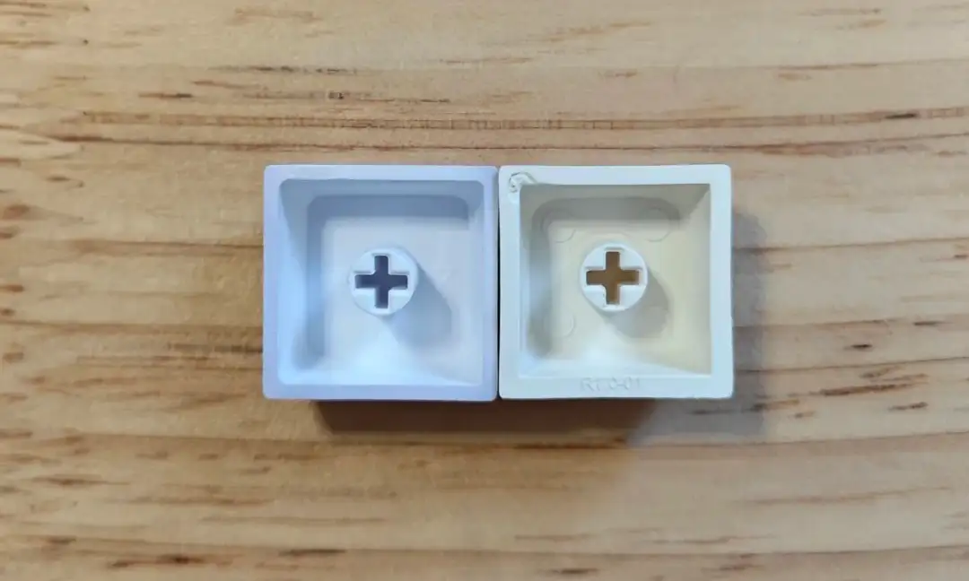 Comparison showing two PBT keycaps with wall thicknesses of 1.0mm and 1.5mm