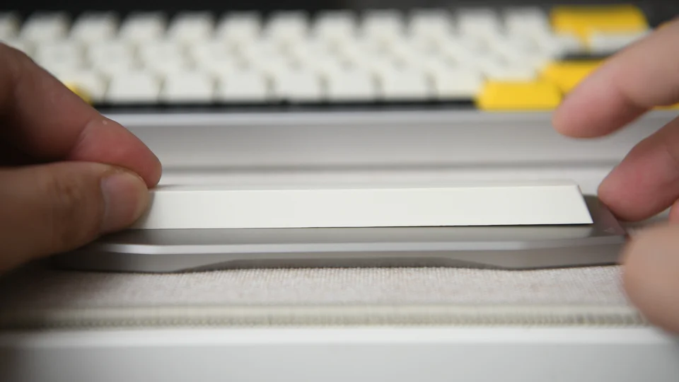 Two PBT spacebars viewed from the side on a flat surface, one with a subtle 2mm upward curve, the other with a pronounced 5mm+ gap