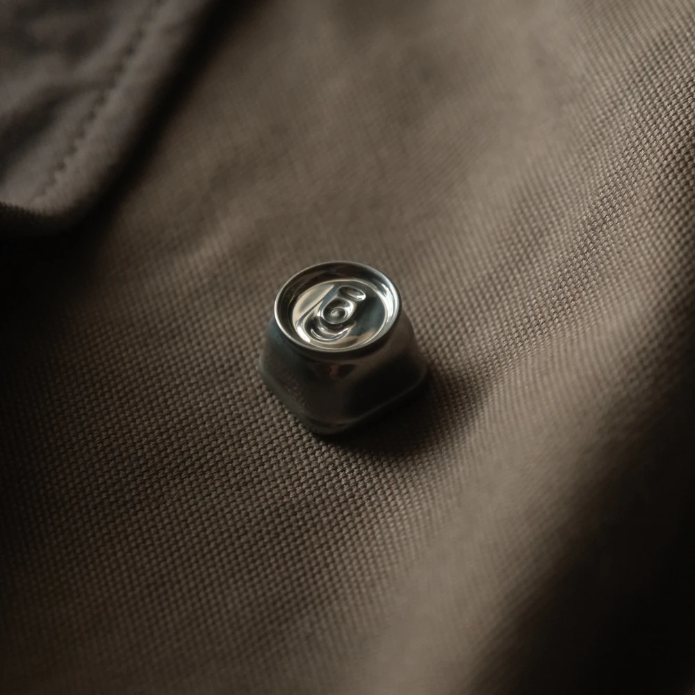Reflective aluminum artisan keycap designed as a crushed soda can for mechanical keyboards.