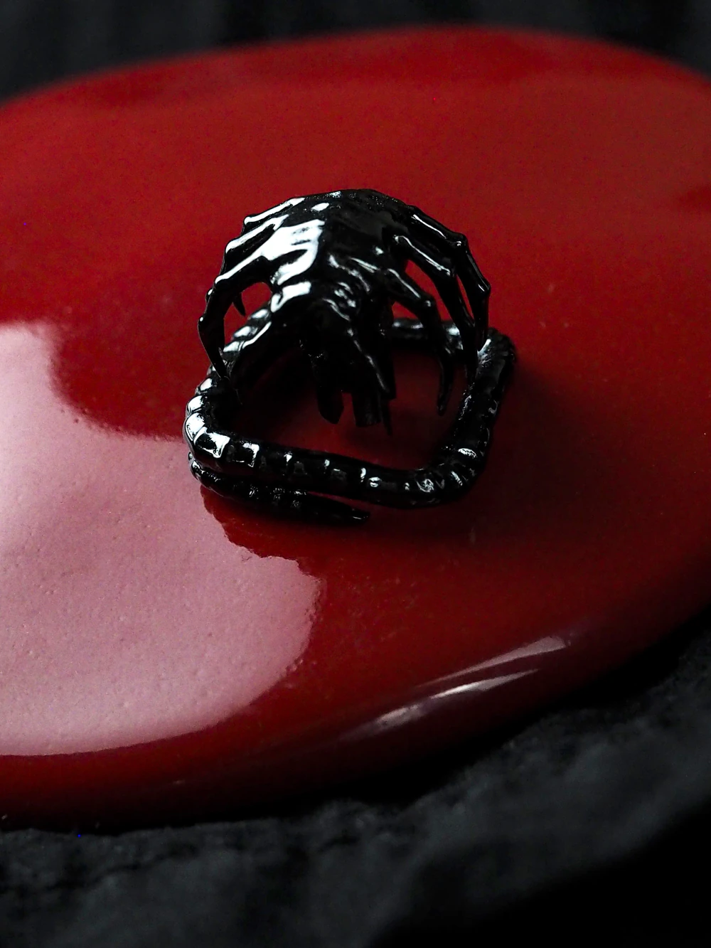 Black Alien Facehugger Keycap on Red Base Black electroplated alien facehugger artisan keycap with visible ribbed tail on a red background.
