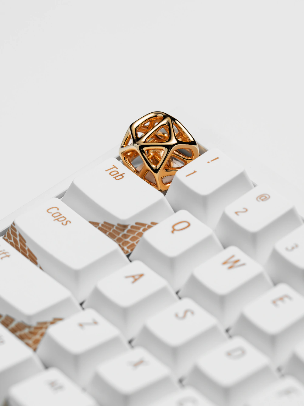 Futuristic Hollow Metal Artisan Keycap Gold Gold futuristic hollow metal artisan keycap replacing the escape key on a white keyboard with gold accents.