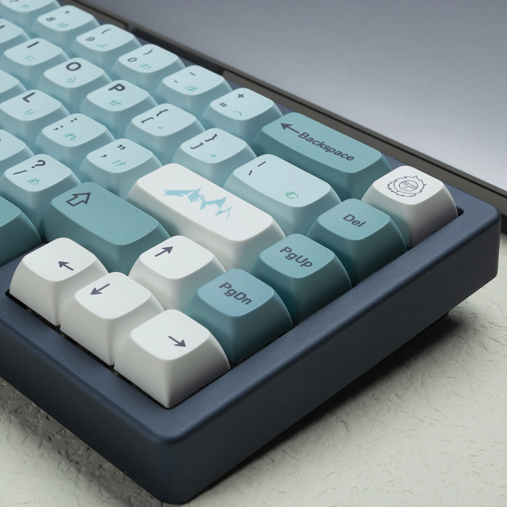 Close-up of blue XDA keycaps with a white mountain accent key and arrow keys