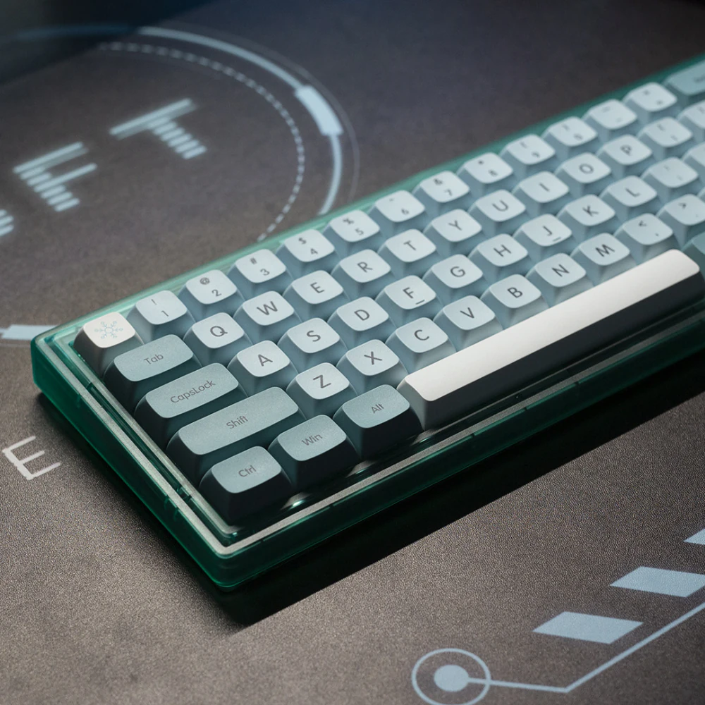 Angled view of blue XDA keycaps with a white spacebar on a dark desk mat