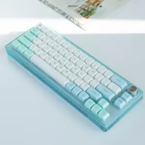 White and mint XDA keycaps on a translucent blue keyboard photographed from above.
