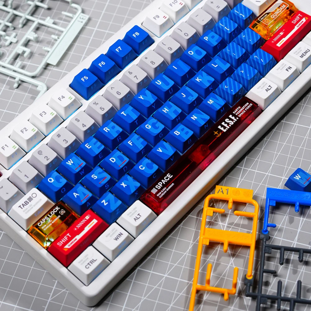 Mecha Armor Blue Alpha Keycaps with Red Spacebar and Sprues Side-lit blue keycaps with red spacebar and gray modifiers on a keyboard beside model sprues.