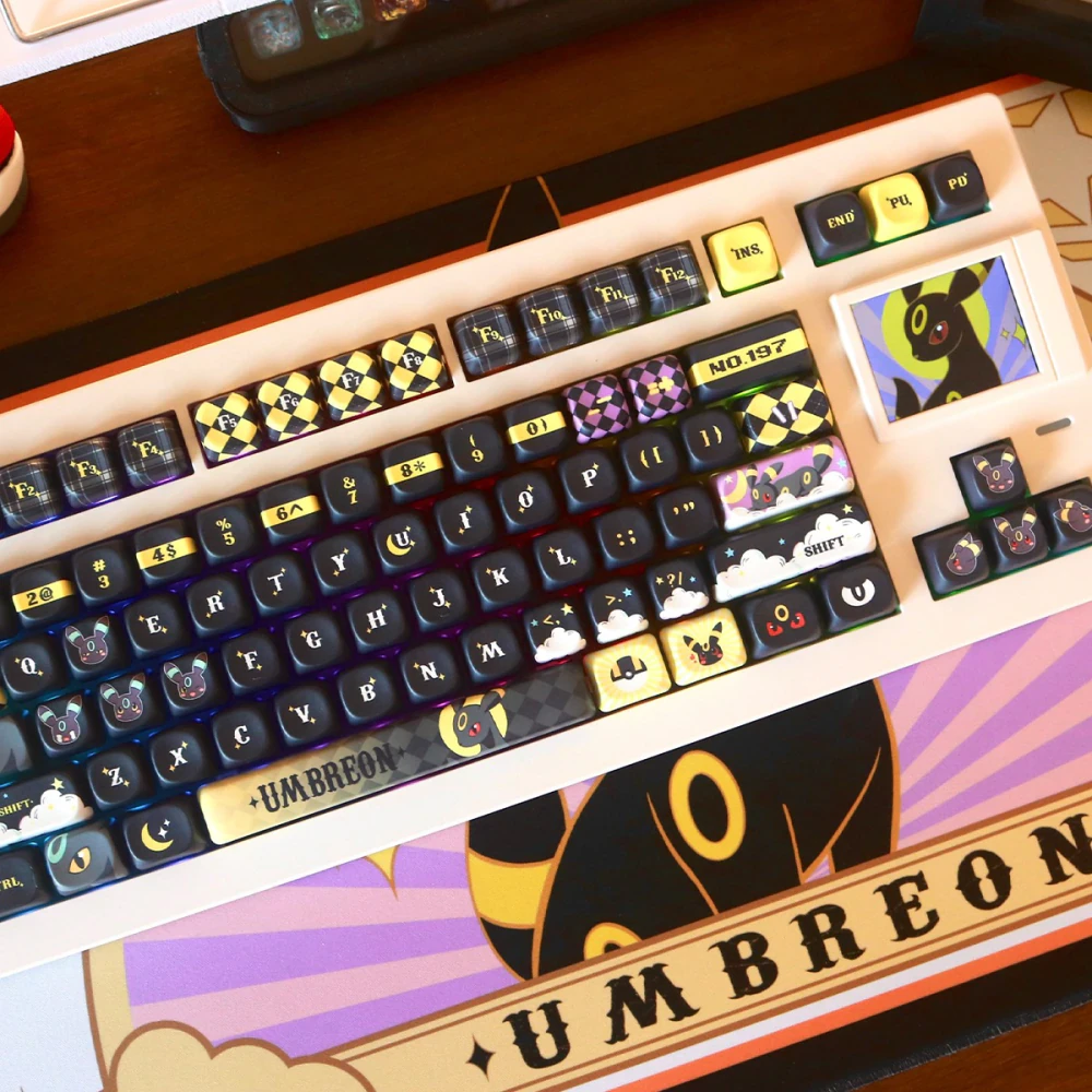 Black and warm gold Moonlit Companion keycaps with decorative accent keys on a cream keyboard.