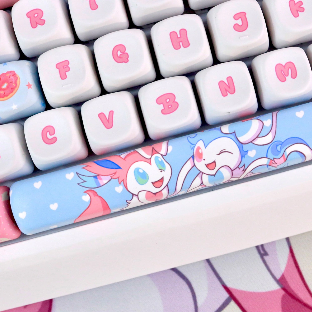 Pastel companion keycaps with pink legends and a blue spacebar featuring cute character art.