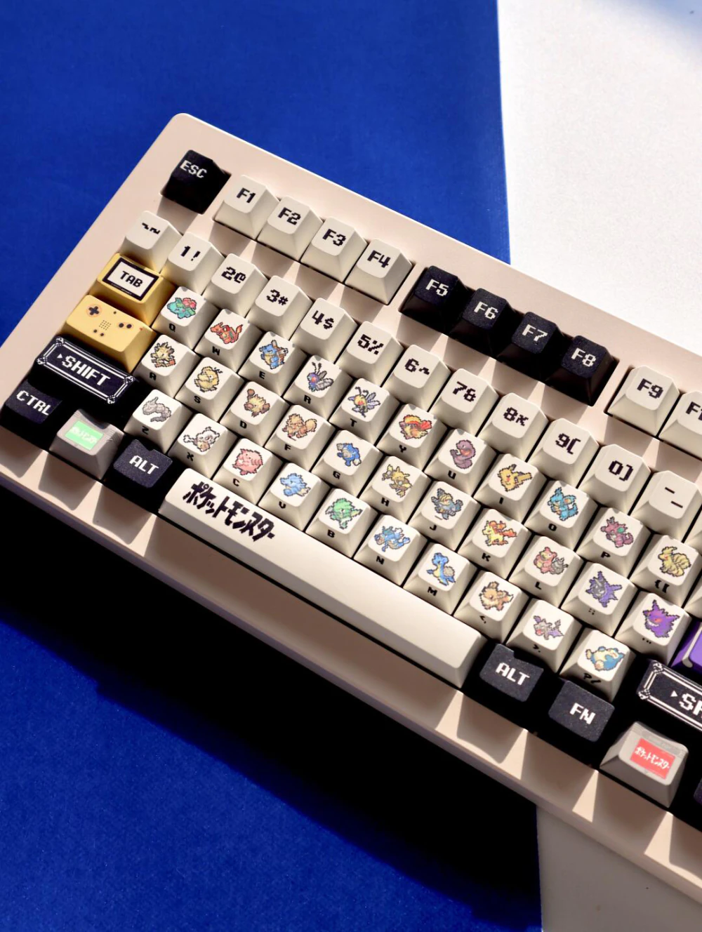 Angled view of retro red and green pixel keycaps on a cream keyboard.