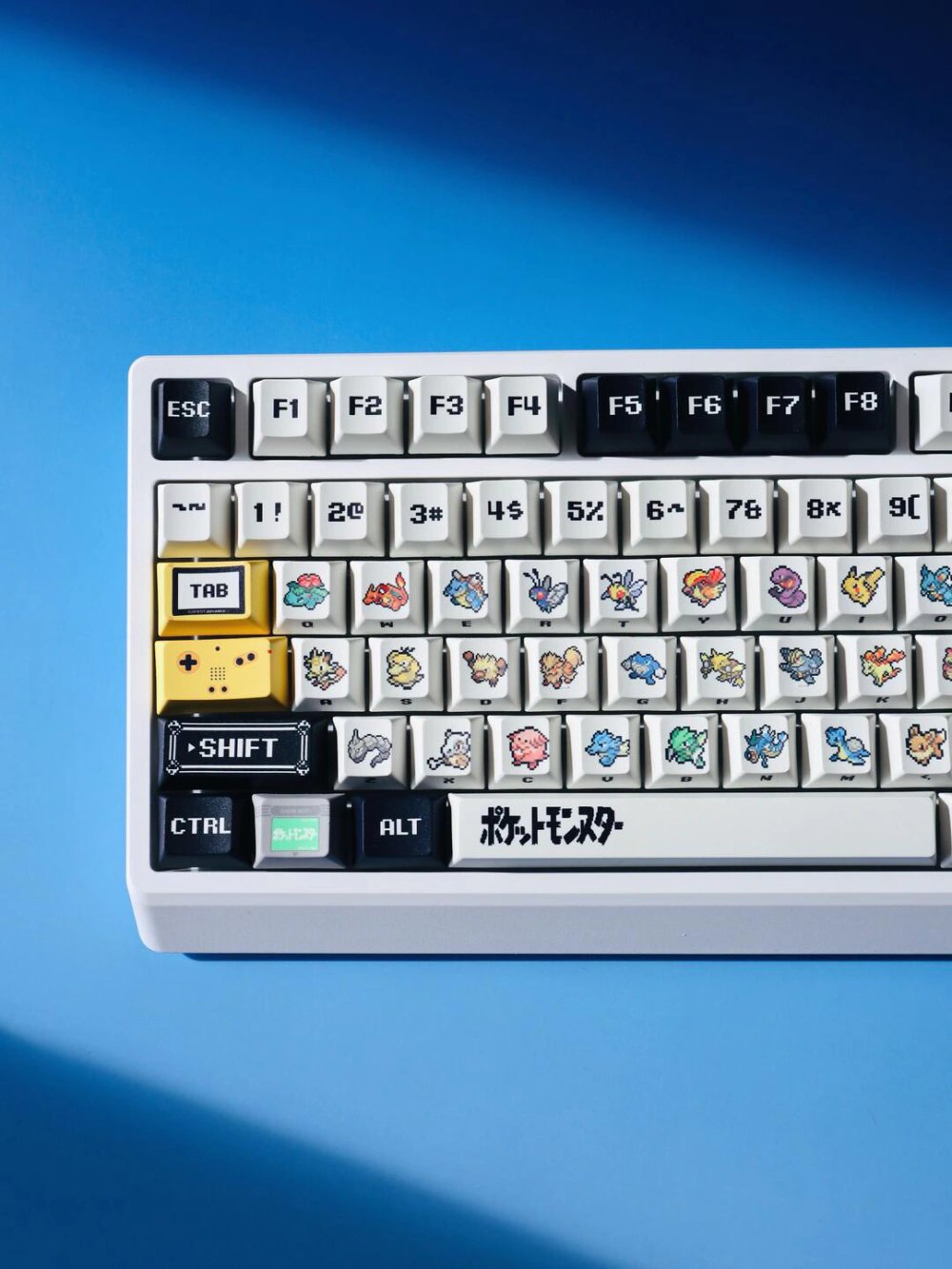 Pixel art keycaps with red and green accents, black modifier keys, and a decorative spacebar.
