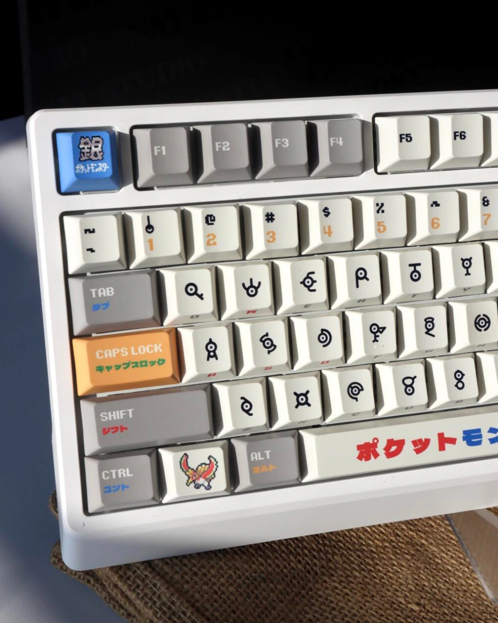 Retro gold silver pixel keycaps installed on white keyboard left angle showing symbol legends and accent keys.