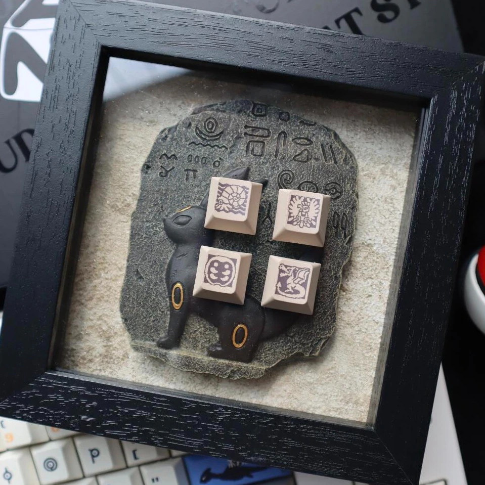 Retro gold silver pixel keycaps arranged on stone tablet in decorative black frame with creature figurine.