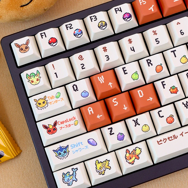 Close-up of Cherry profile pixel companion keycaps featuring cute pixel creatures and orange arrow keys.
