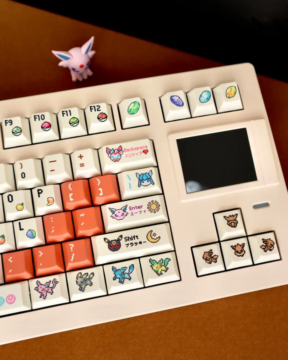 Pixel companion keycaps on a mechanical keyboard with orange accents and white keys.