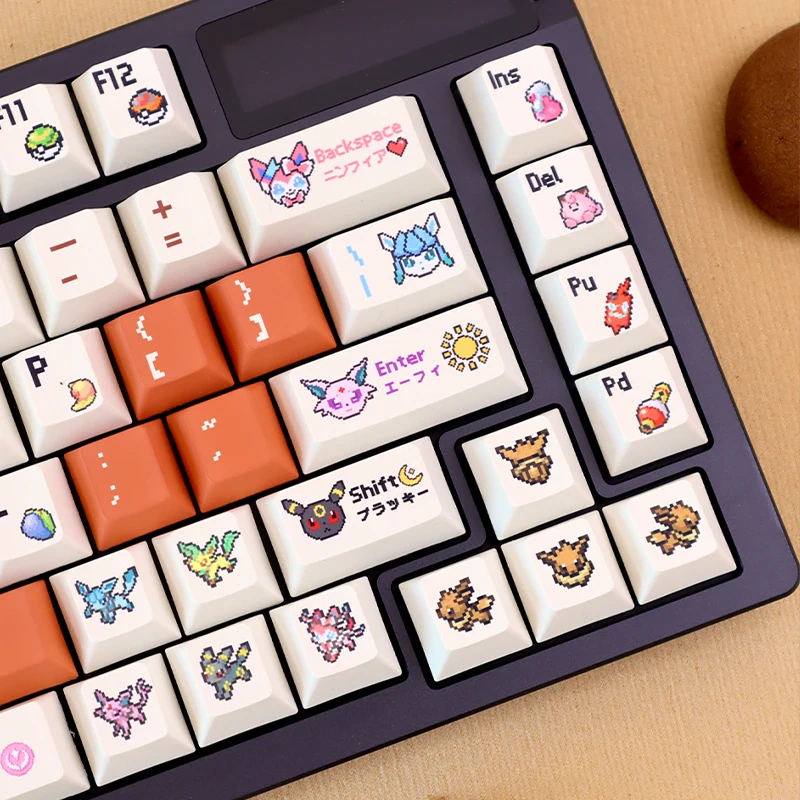 Close-up of retro pixel companion keycaps showing orange accent keys and pixel artwork on a keyboard.