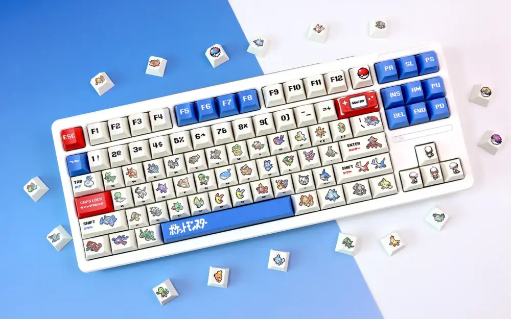White keyboard with retro ruby and sapphire cherry profile pixel art keycaps and loose caps on split blue white background.