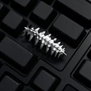 Close-up of a silver creature shaped keycap installed on a black keyboard.