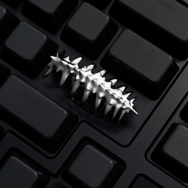 Sci-Fi Creature Silver Keycap Close Up Close-up of a silver creature shaped keycap installed on a black keyboard.