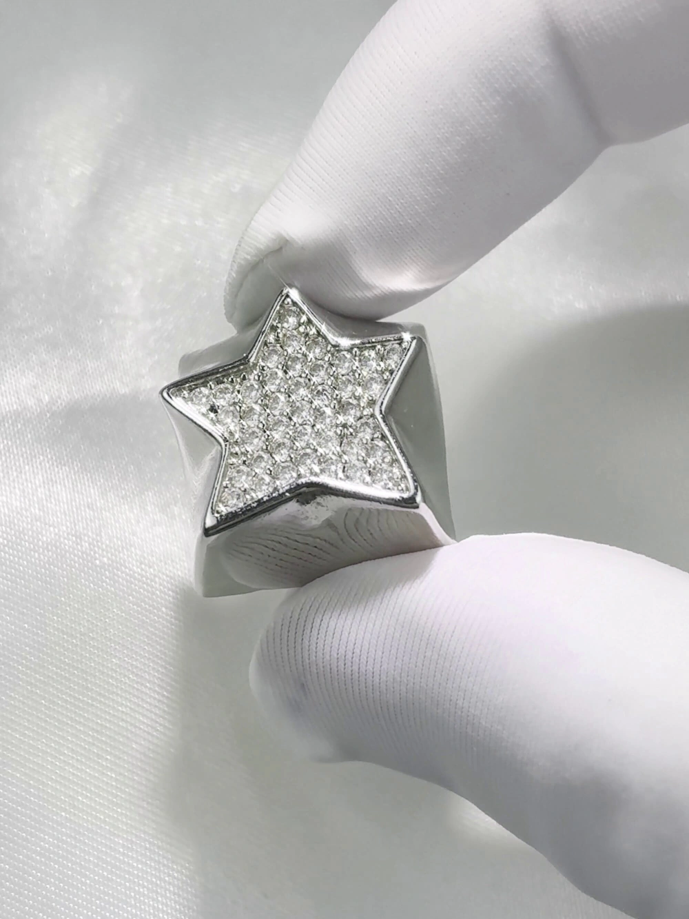 Close-up of the sparkling star diamond metal artisan keycap held by white gloved fingers.