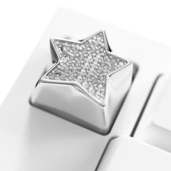 Sparkling Star Diamond Metal Keycap Macro Shiny star keycap featuring an electroplated platinum finish and cubic zirconia stones on a white keyboard.