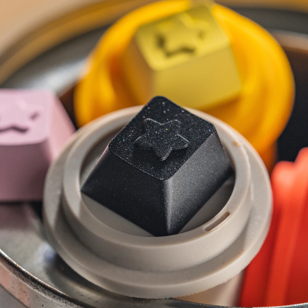 Black star themed metal artisan keycap shown close up in a round holder.