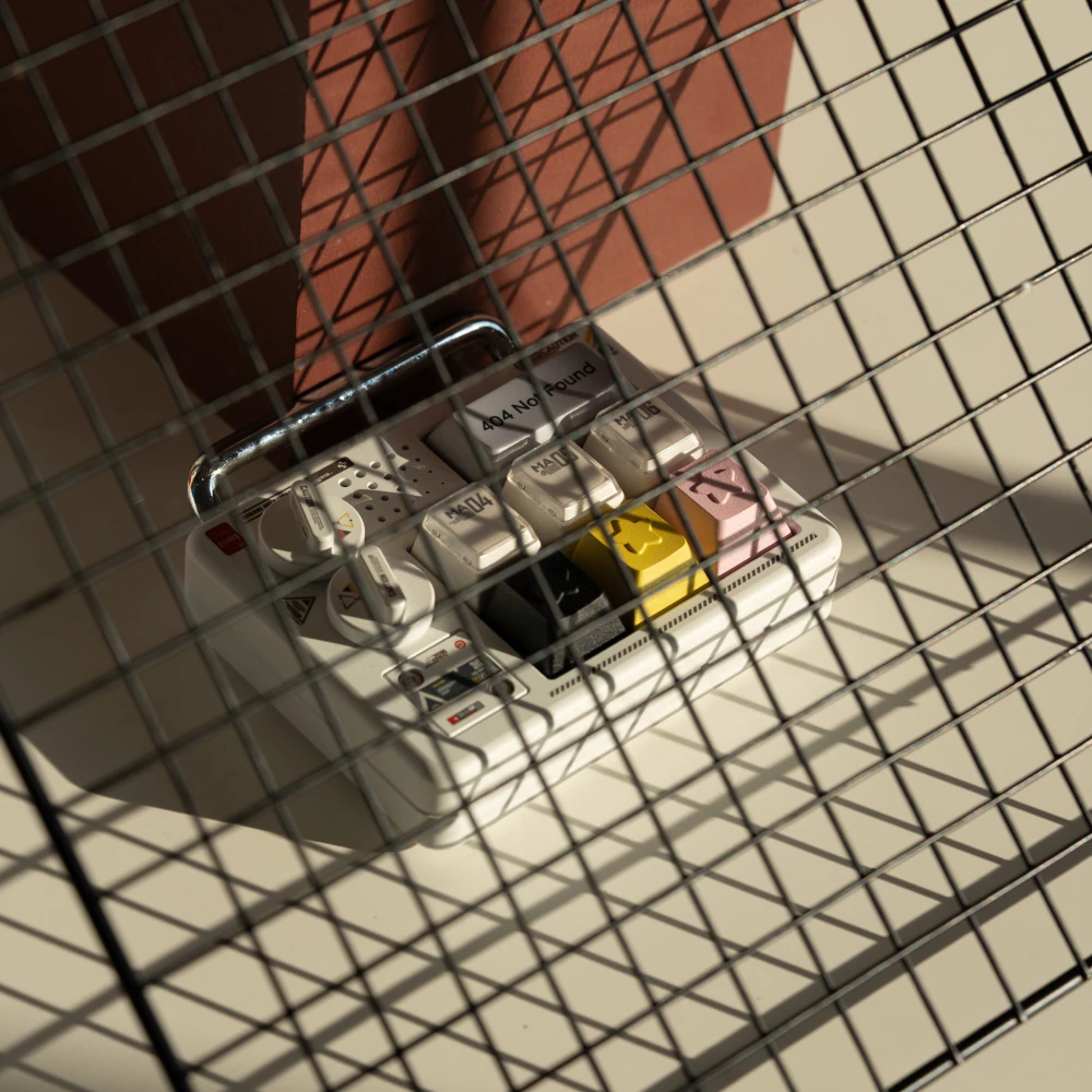 Star keycaps on a small display seen through a wire grid in sunlight.