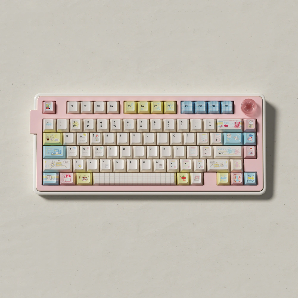Front view of a pink keyboard fitted with Cozy Journal keycaps on a light background.