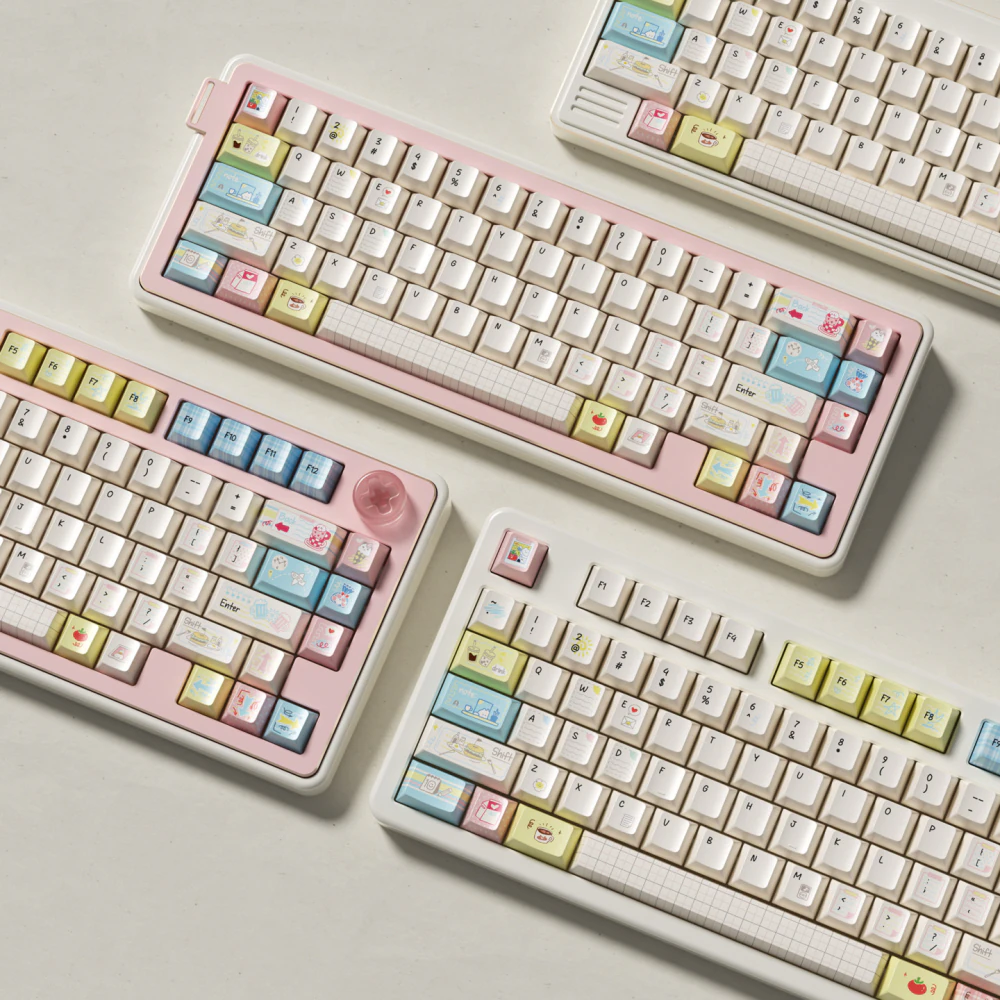 Three keyboards fitted with Cozy Journal keycaps, viewed from above on a light background.