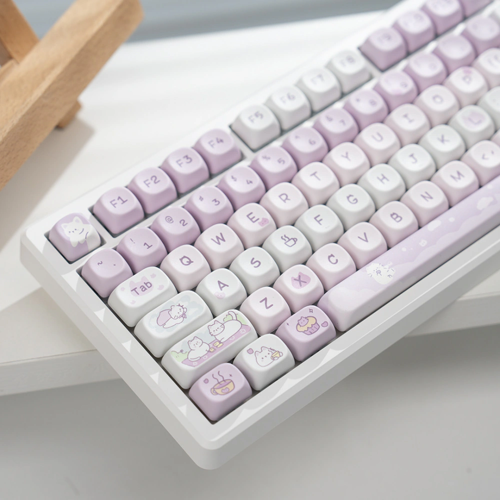 Close angled view of pink and white keycaps with cat and dessert illustrations