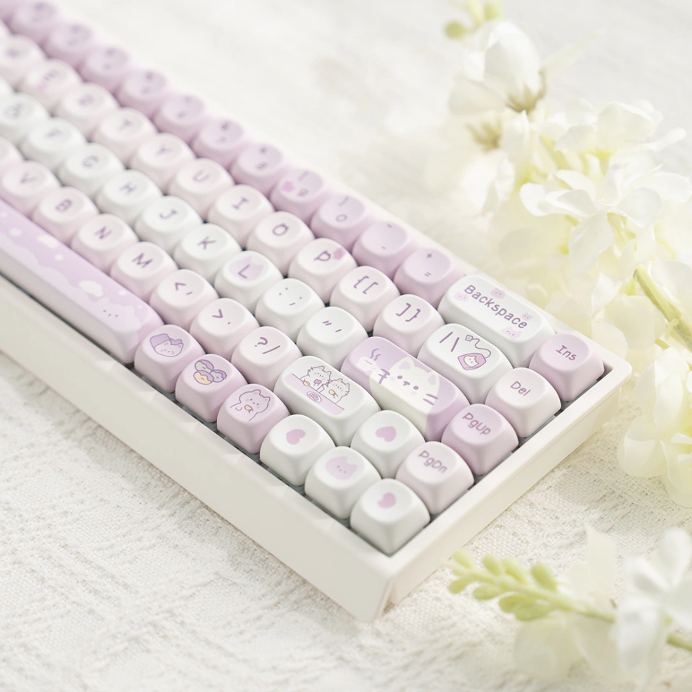 Right side of a white keyboard with pink cat themed keycaps and white flowers nearby