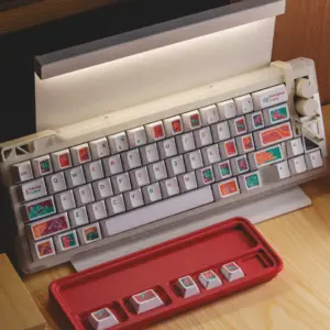 White keyboard fitted with colorful Fantasy Tunnel mythical creature keycaps beside a red tray.