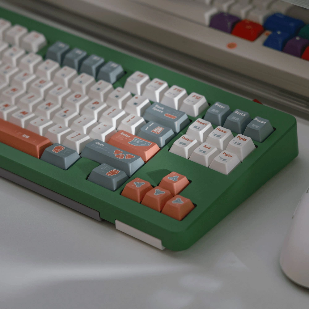 Close-up of a green keyboard case fitted with white, gray-green, and salmon GUARDIAN keycaps.