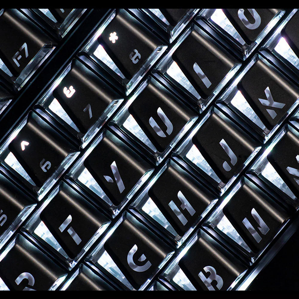 Diagonal close-up of black Prism keycaps with visible shine-through legends