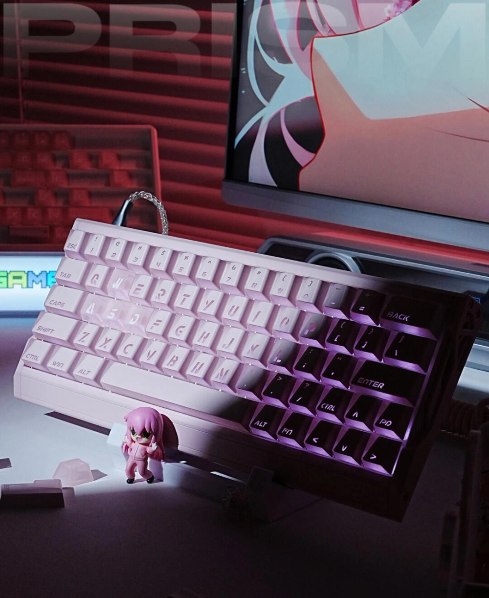 Keyboard with pink and black Prism shine-through keycaps beside a small figure and monitor