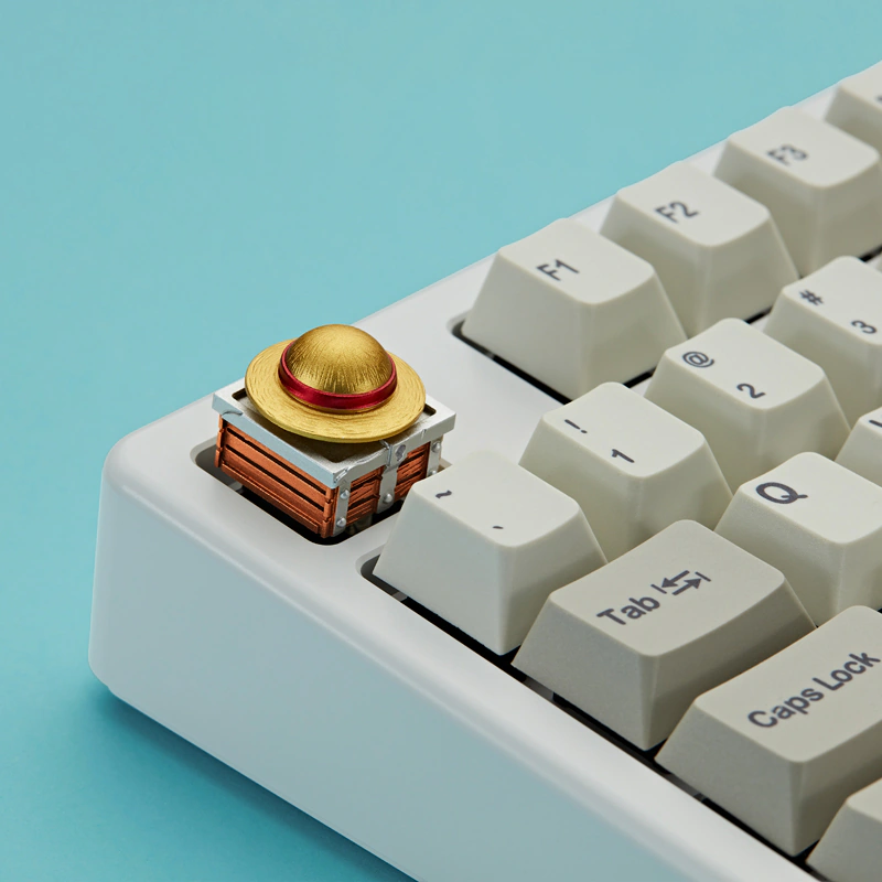 Gold and red hat keycap on a black mechanical keyboard with warm backlighting.