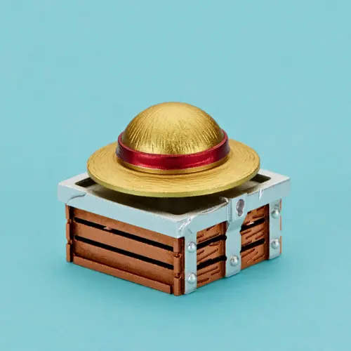 About Us Gold rotating hat keycap with a red band and layered copper-tone metal base.