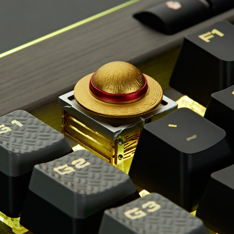 Rotating Straw Hat Aluminum Artisan Keycap Front view of a textured gold hat keycap with a silver frame and copper-tone base.
