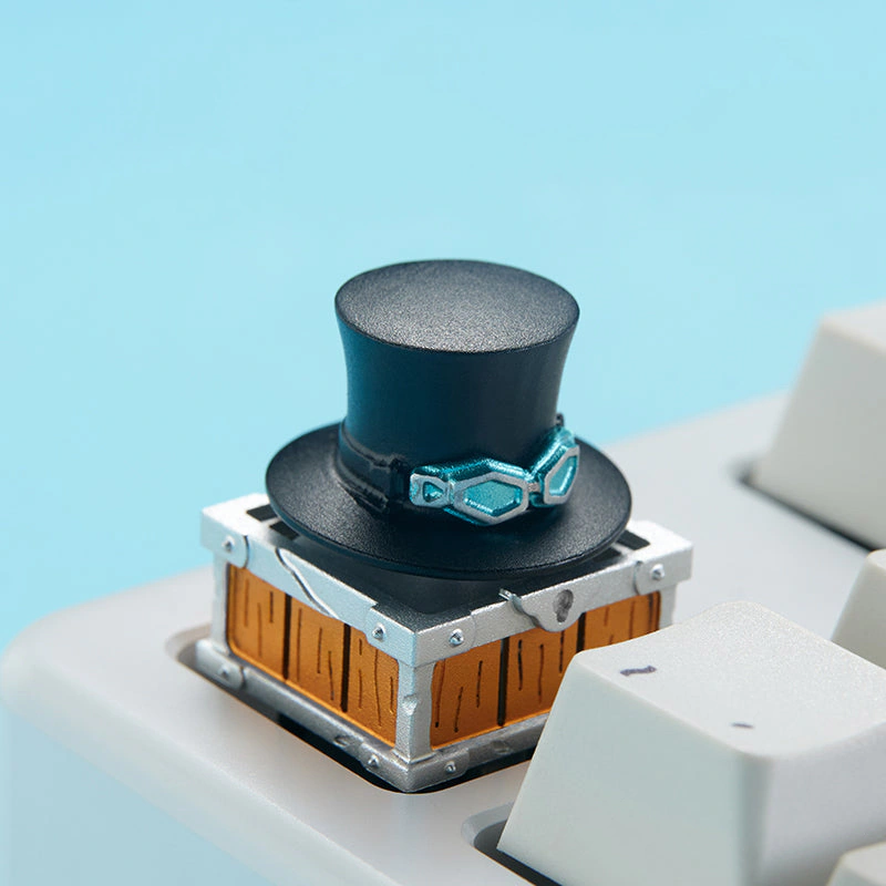 keysfusion-zomoplus-sabo-rotating-black-top-hat-aluminum-artisan-keycap-keyboard-mount Black top hat keycap with teal goggles mounted on a white mechanical keyboard.