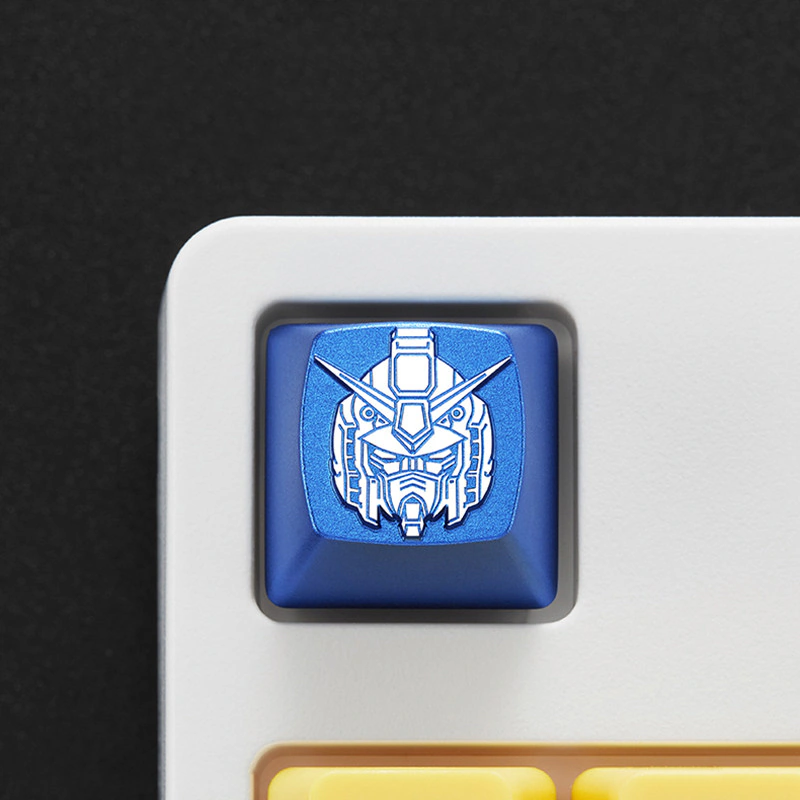 Front view of a blue metal mecha head keycap on a white keyboard.