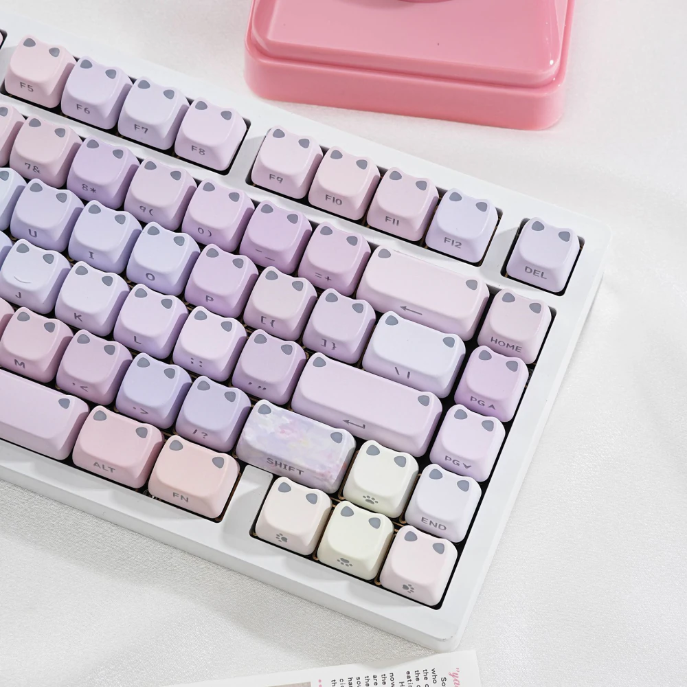 Pastel lilac and pink cat-ear keycaps with side-printed legends