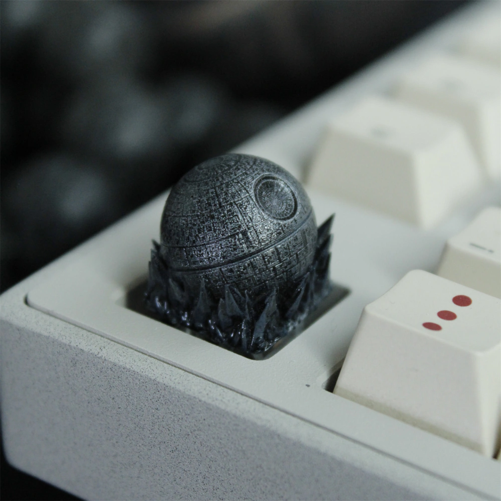 Dark gray spherical keycap with a circular feature installed in a light keyboard.