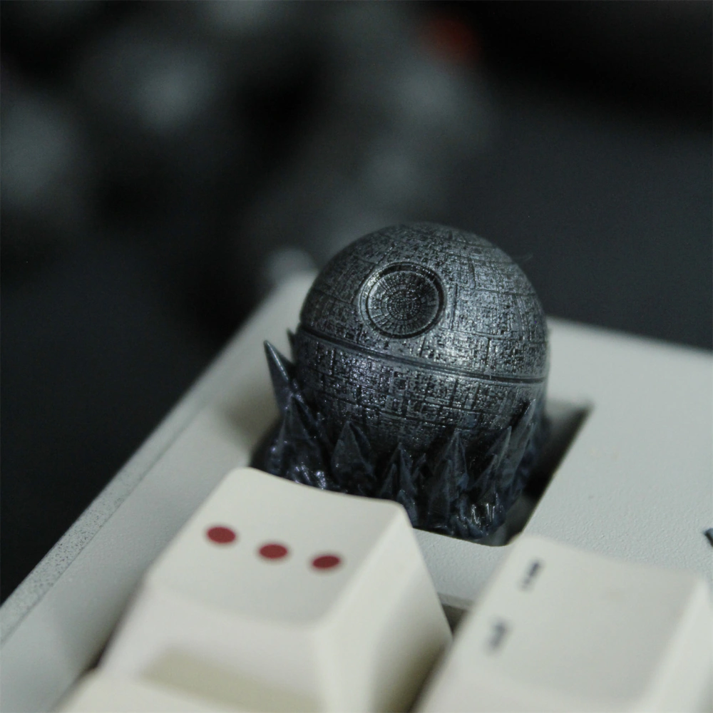 The circular detail and dense panel texture are visible on a dark spherical keycap above the keyboard.